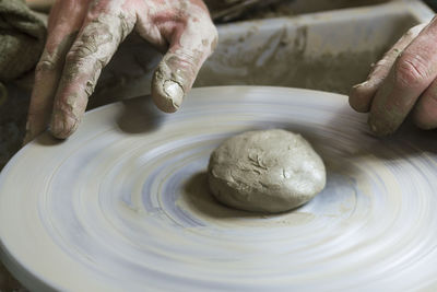 Cropped hand of potter using pottery wheel