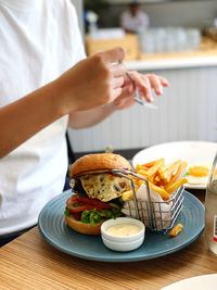 Midsection of woman having food in restaurant