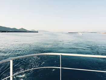 Boat sailing in sea against clear sky