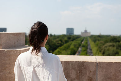 Rear view of woman standing against wall