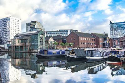 Boats moored at harbor against sky