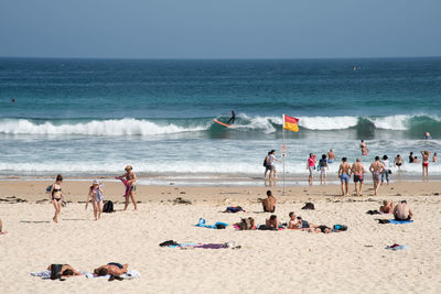 Crowd at beach against sky