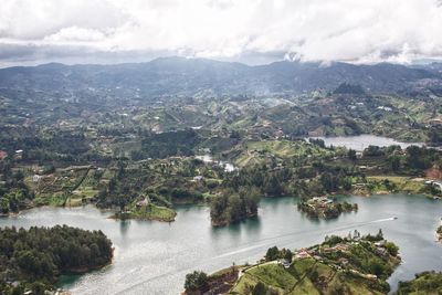 Scenic view of river and mountains against sky