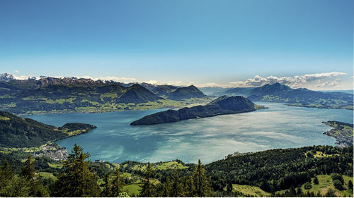 Scenic view of lake and mountains against clear blue sky