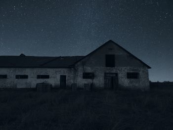 Abandoned house on field against sky at night