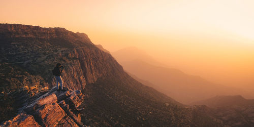 A man on the ledge of a cliff in tanomah, saudi arabia