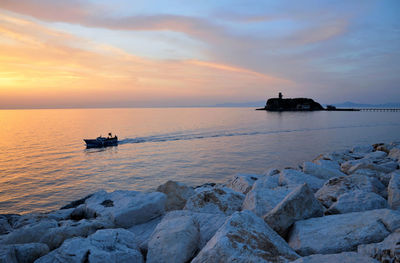 Scenic view of sea against cloudy sky during sunset