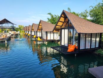 House by lake against sky