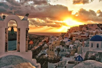 Buildings in city against sky during sunset