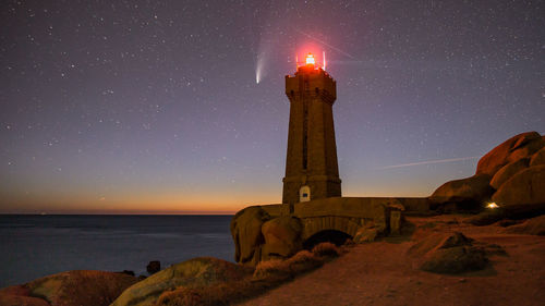 Lighthouse against sky at night