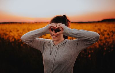 Woman against field at sunset