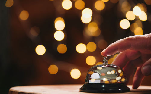 Close-up of hand holding illuminated lantern at night