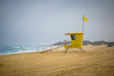 Lifeguard hut on beach against clear sky