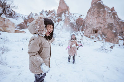 Side view of girl standing on snow