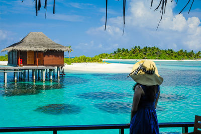 Rear view of man in swimming pool against sea