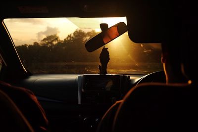 Man driving car during sunset
