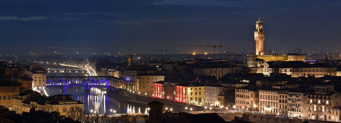 Panoramic view of illuminated buildings against sky at night