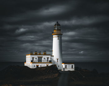 Lighthouse by sea against sky