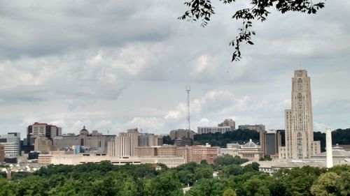 View of cityscape against cloudy sky