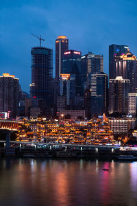 Illuminated buildings in city against sky at night