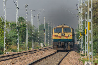 Train by railroad tracks against trees