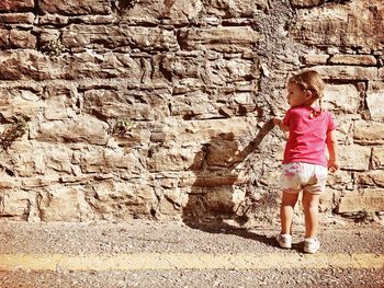 Full length of woman standing against wall