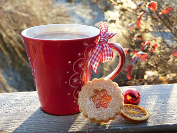 Close-up of coffee cup with cookie on table