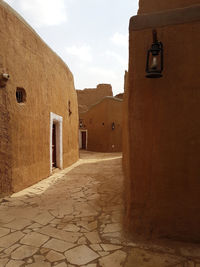 Alley amidst buildings in city against sky