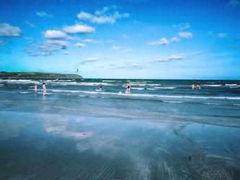 People on beach against blue sky