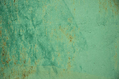 Aged green weathered textured background with brush strocks or grunge rough surface backdrop.