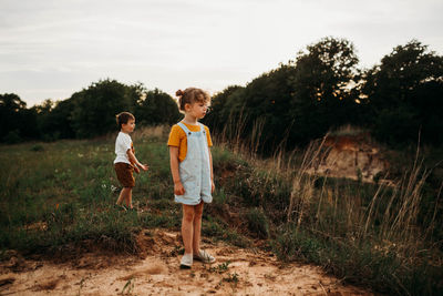 Young brother and sister outside hiking at sunset