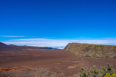 Scenic view of desert against blue sky