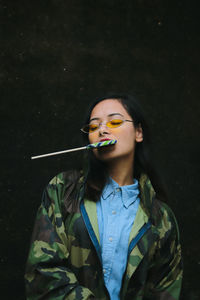 Smiling young woman with candy outdoors