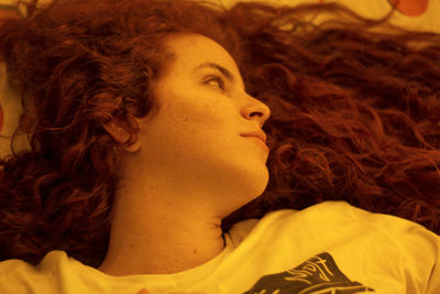 Close-up portrait of young redhead woman looking away