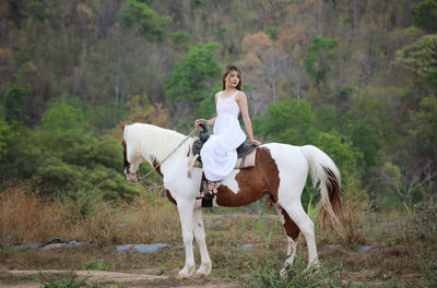 Side view of man riding horse