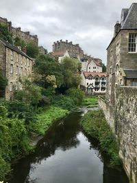 Canal amidst buildings against sky