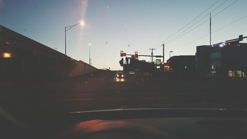 Road in city against sky at dusk