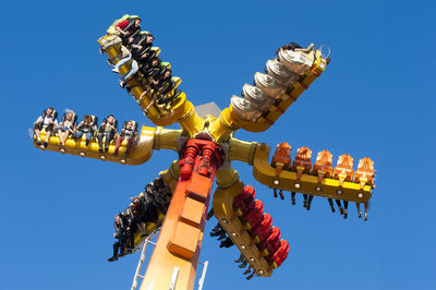 Low angle view of illuminated lanterns against clear blue sky