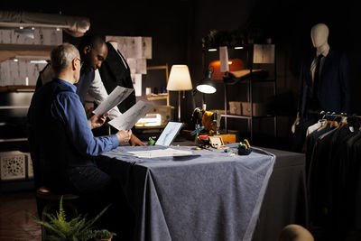 Side view of woman using mobile phone while sitting on table