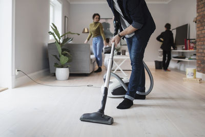 Low section of people standing on hardwood floor at home