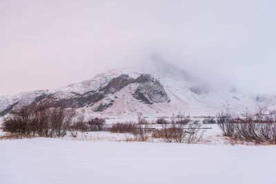 Snow covered landscape against sky