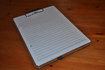 High angle view of papers and writing pad on table