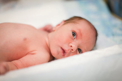 Portrait of cute baby lying on bed