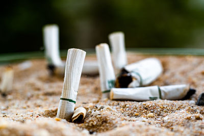 Close-up of cigarette on sand