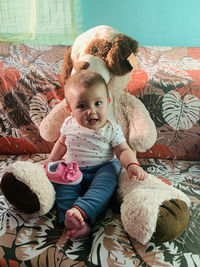 Portrait of cute baby boy sitting on sofa