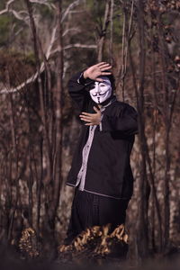 Full length of man wearing mask in forest