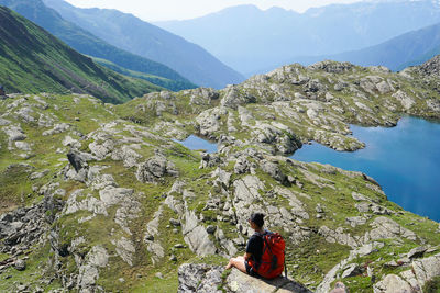 Women amidst rocks against mountains