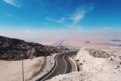 Road amidst landscape against blue sky