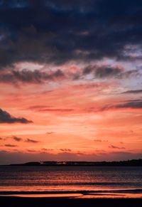 Scenic view of sea against dramatic sky during sunset