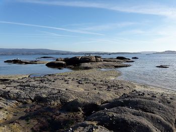 Rocks on beach against sky
